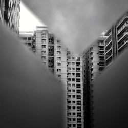 Low angle view of buildings seen through torn paper