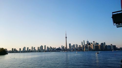 City by river against clear sky