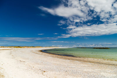 Scenic view of beach against blue sky