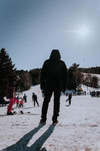Rear view of people on snow against sky