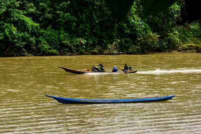 People in boat against trees