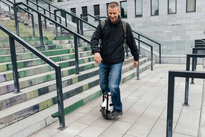 Man riding fast on electric unicycle on city street. mobile portable individual transportation