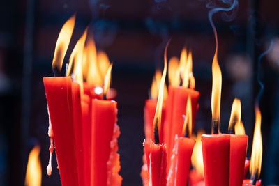 Rows of burning red candles are used in religious prayers