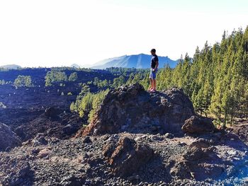 Full length of man standing on rock against sky