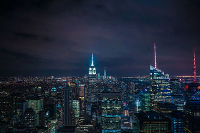 Illuminated empire state building in city at night