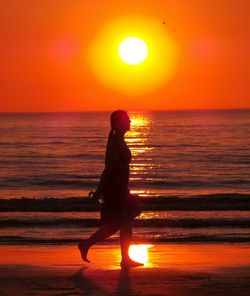 Silhouette of people in sea at sunset