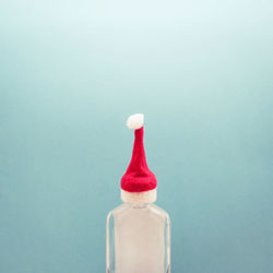 Close-up of red wine bottle against white background