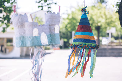 Colorful decoration hat hanging against trees