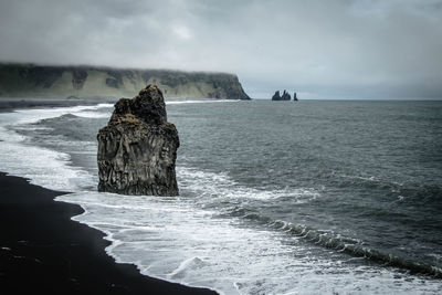 Scenic view of rocks in sea against sky