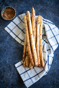 Grissini - italian bread sticks with dried herbs on a blue background. close up.