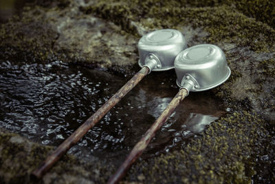 High angle view of ladles by water on rock