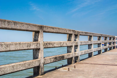 Built structure by sea against clear blue sky