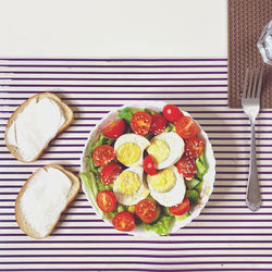 High angle view of food on table. eggs, cherry, avocado, cucumber, sesame, olive oil-tasty breakfast