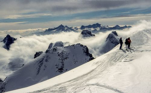 Rear view of mountaineers standing on snowcapped mountains