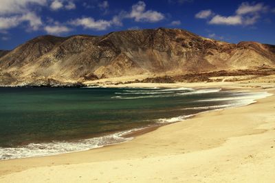 Scenic view of beach and mountains against sky