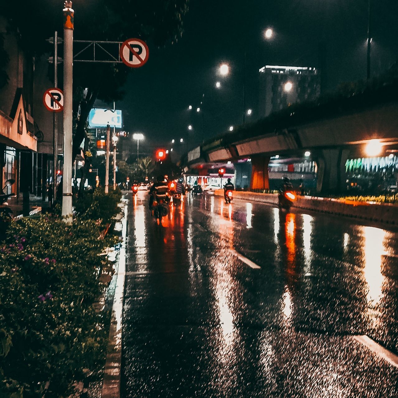 night, illuminated, city, architecture, street, transportation, built structure, building exterior, evening, light, road, mode of transportation, darkness, water, wet, lighting, sign, nature, street light, car, motor vehicle, rain, city life, no people, city street, reflection, lighting equipment, outdoors, urban area, road sign, land vehicle, cityscape