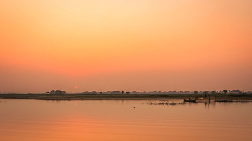 Scenic view of lake against romantic sky at sunset