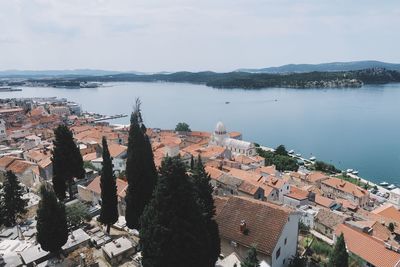 High angle view of townscape by sea against sky