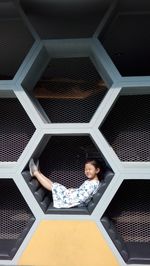 Full frame shot of hexagonal metal grate, little girl, unique bench, unique position, relax