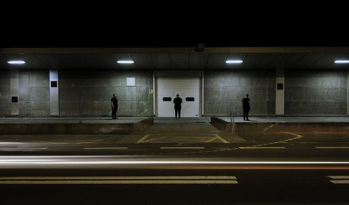 Multiple image of man standing by illuminated building at night