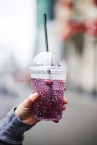 Cropped hand of person holding drink in disposable cup