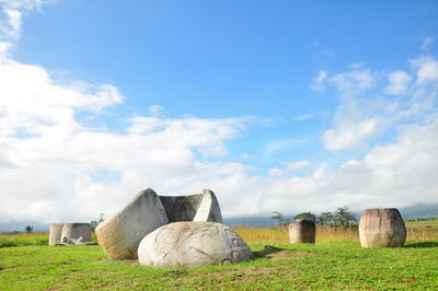 Hay bales on field against sky