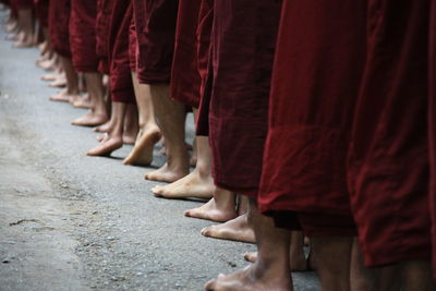 Low section of monks standing on road