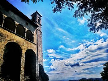 Low angle view of bell tower against cloudy sky