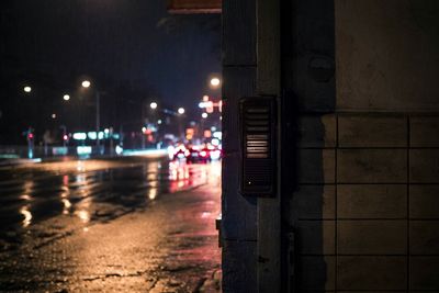 Illuminated road by street against sky at night