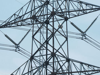 Low angle view of electricity pylon against sky