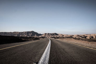 Road leading towards mountain against sky