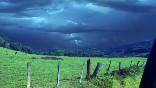 Scenic view of green landscape against cloudy sky