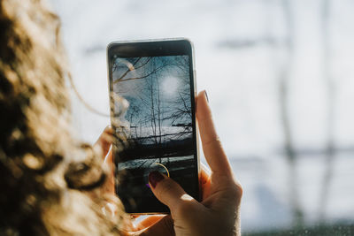 Close-up of hand holding smart phone outdoors