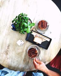 Cropped hand picking coffee cup from table