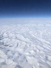 Aerial view of snowcapped landscape against sky