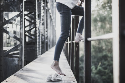 Low section of woman standing on railing