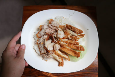 High angle view of hand holding bread in plate