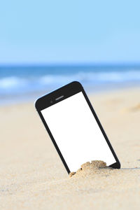 Low angle view of mobile phone on beach