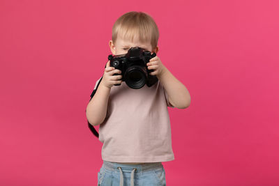 Full length of a man photographing against red background