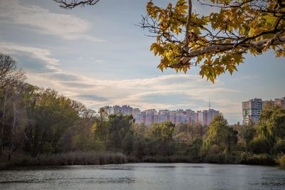 Scenic view of river by buildings against sky