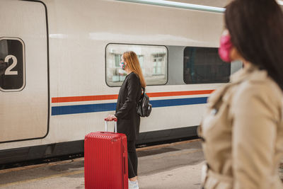 Rear view of woman on train at railroad station