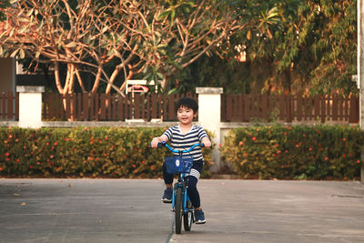 Rear view of woman riding bicycle on road