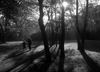 Mother and son amidst trees at forest