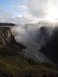 Scenic view of waterfall against sky
