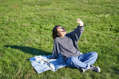 Portrait of young woman sitting on field