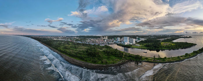 High angle view of city by sea against sky