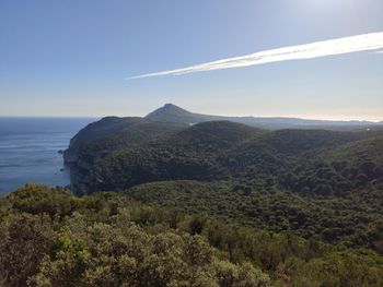 Scenic view of sea and mountains against sky