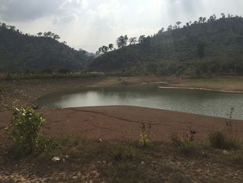 Scenic view of lake against cloudy sky