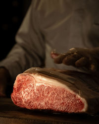 Midsection of man preparing food on cutting board