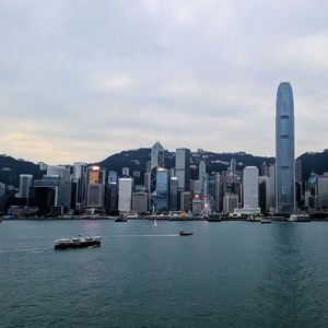 Sea by buildings against sky in city